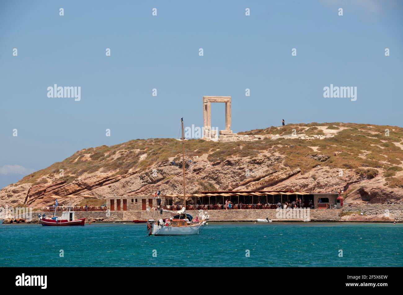 Panoramablick auf Portarae und den Tempel des Apollo, Naxos, Griechenland. Im Hintergrund ist der wolkenlose blaue Himmel zu sehen. Reise- und Tourismuskonzept Stockfoto