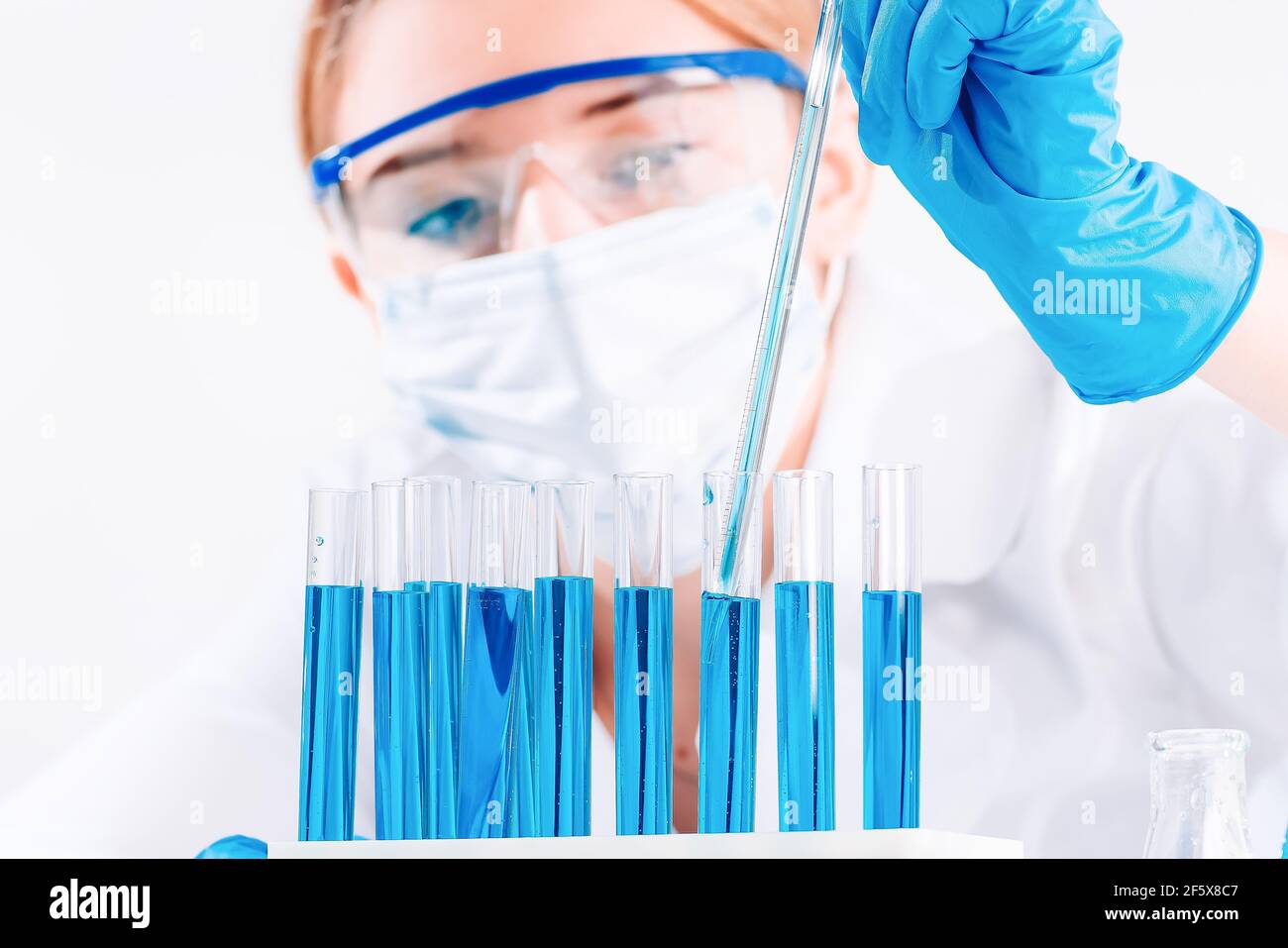 Forscherin nutzt Micropipette-Abfüllsteströhrchen.EINE Laborantin in einem Labor mit Reagenzgläsern produziert Impfstoffproben. Entwicklung Stockfoto