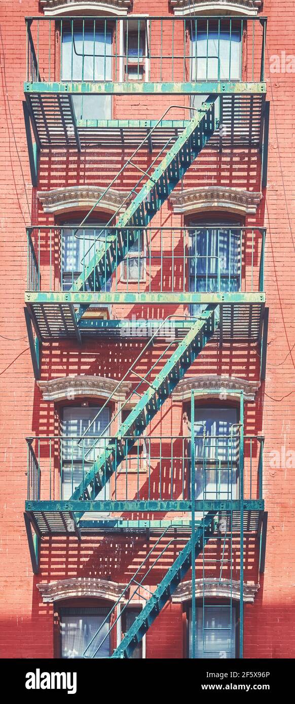 Altes Backsteingebäude mit eiserner Feuerschutzflosse, Farbtonung angewendet, New York City, USA. Stockfoto