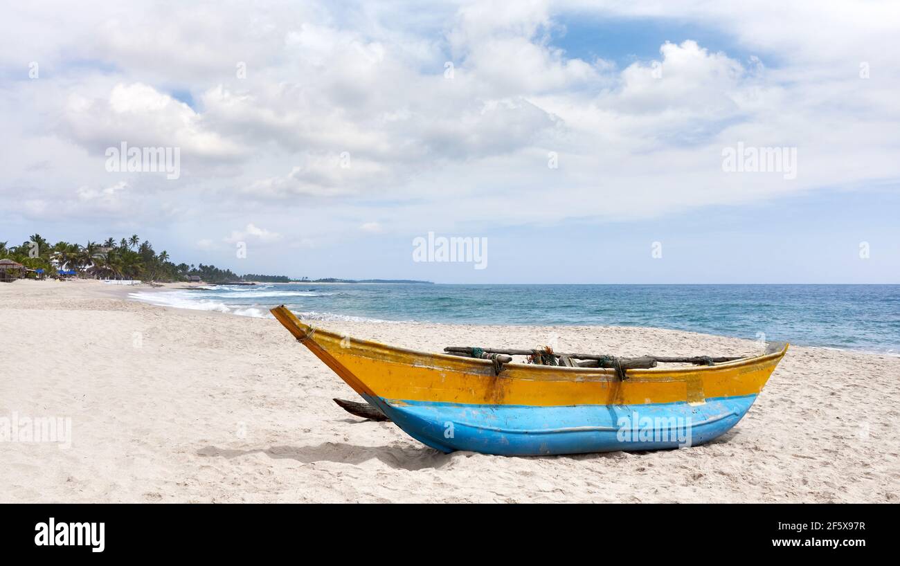 Kleines Fischerboot an einem leeren tropischen Strand, Sri Lanka. Stockfoto