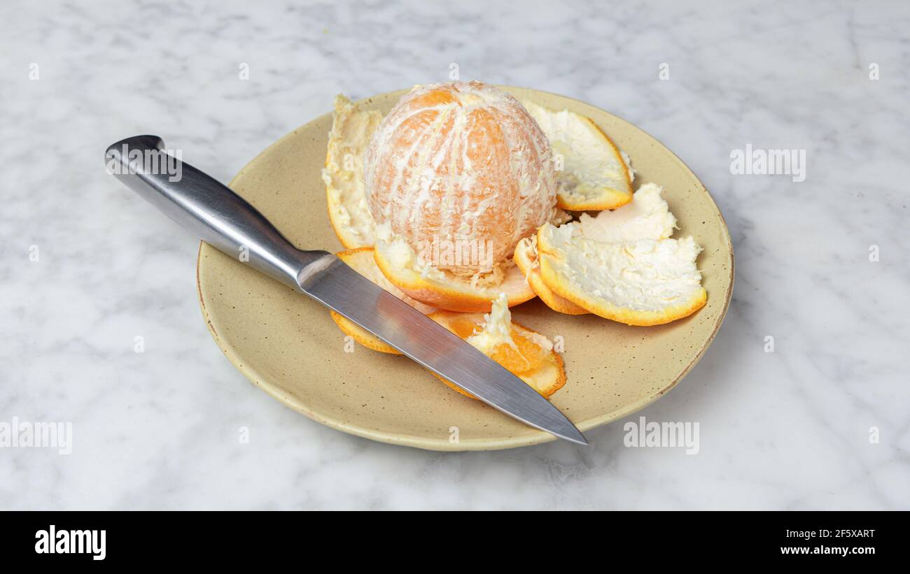 Geschälte Orange auf einem Teller. Gesunde Ernährung Konzept Stockfoto