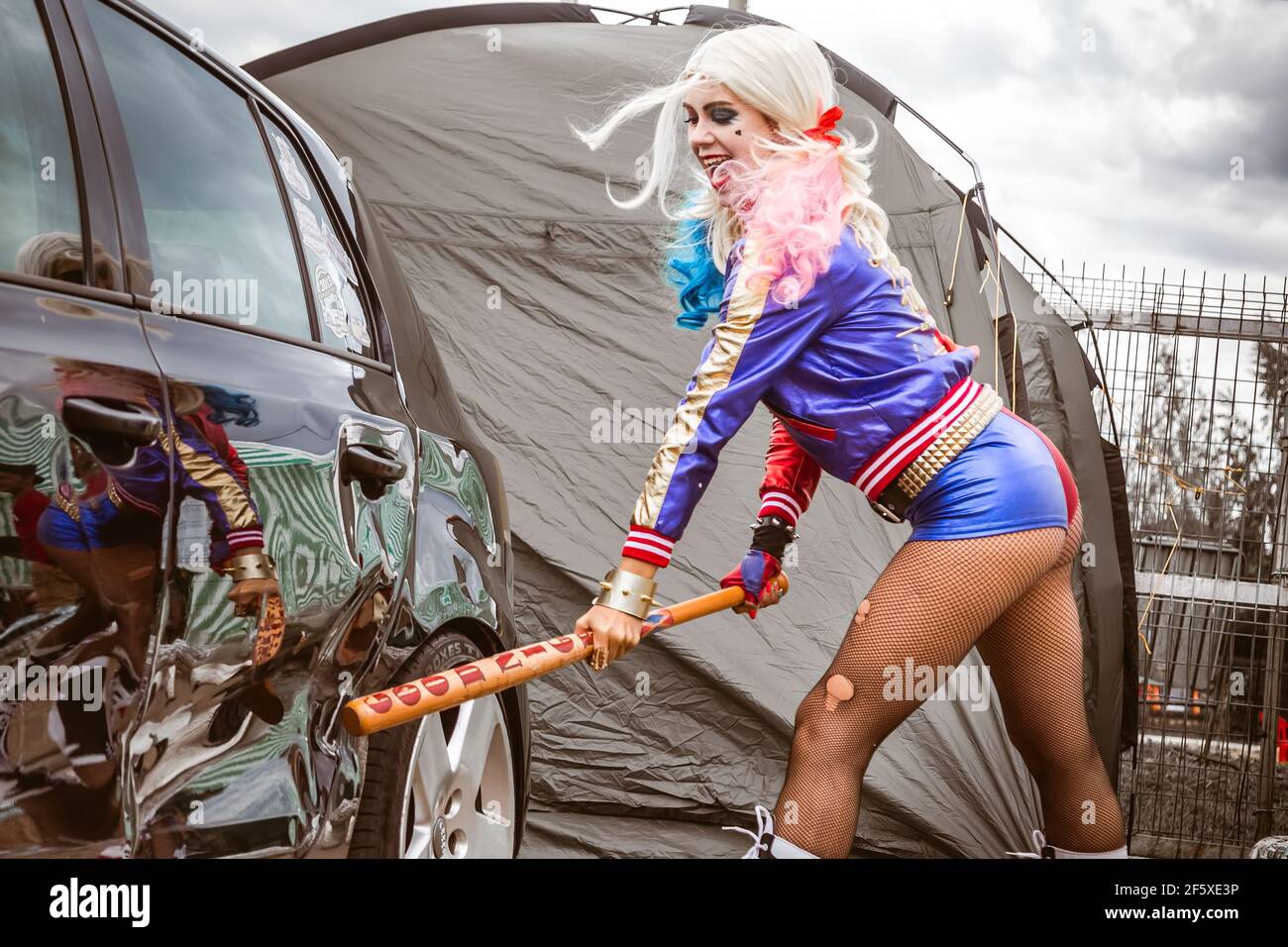 Moskau, Russland - 06. Juli 2020: Harley Quinn trifft mit einem  Baseballschläger auf ein geparktes schwarzes Auto.