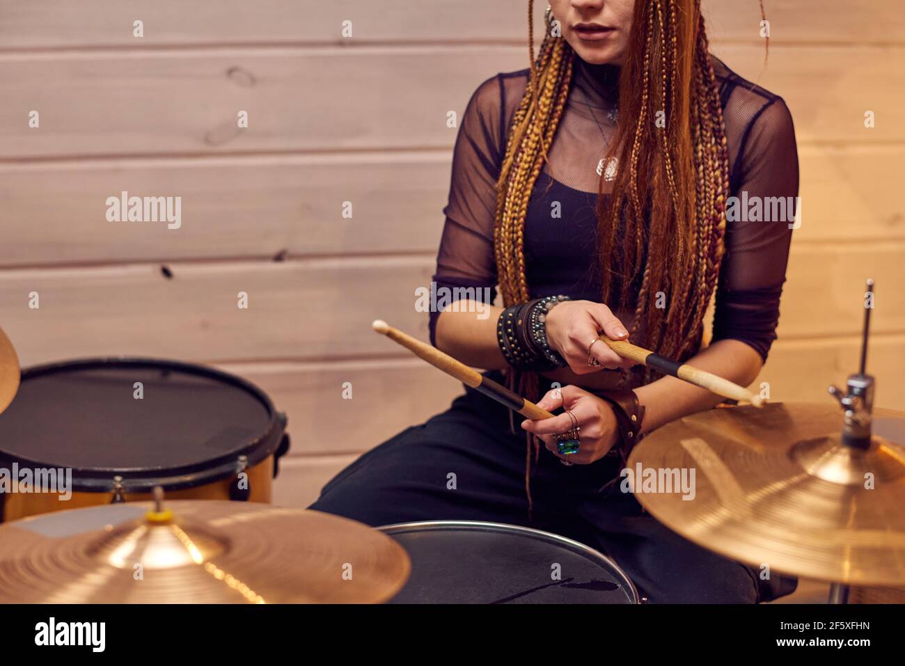 Junge Frau lernen, Schlagzeug spielen während der musikalischen Lektion in Das Studio Stockfoto