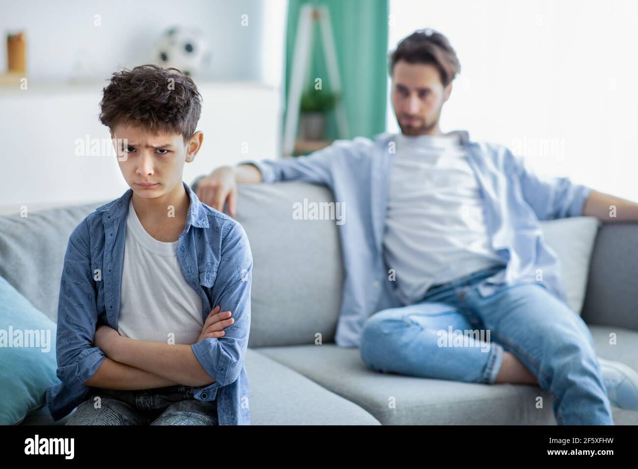 Familiengenerationen Konflikt. Verärgert Junge und Vater nicht reden nach Streit, Sohn und Vater sitzen getrennt auf der Couch Stockfoto
