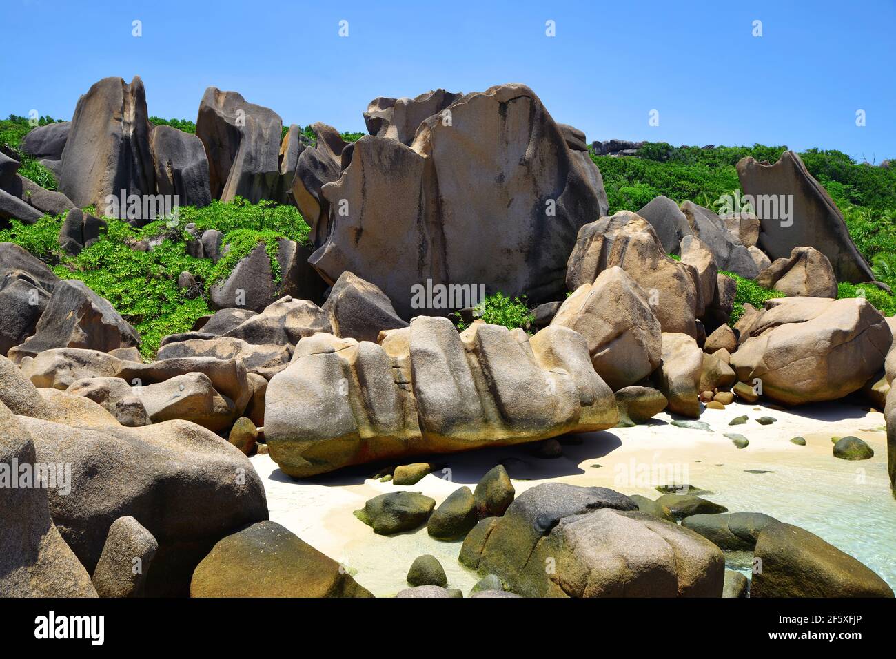 Anse Marron Strand mit großen Granitfelsen auf der Insel La Digue, Seychellen. Tropische Landschaft mit sonnigem Himmel. Exotisches Reiseziel. Stockfoto