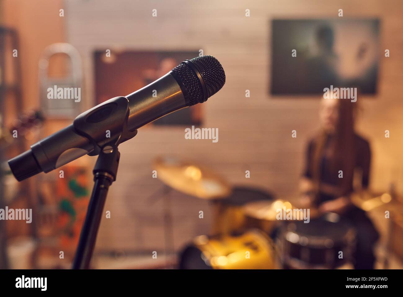 Nahaufnahme des Mikrofons für Sänger im Musikstudio mit Schlagzeuger Im Hintergrund Stockfoto
