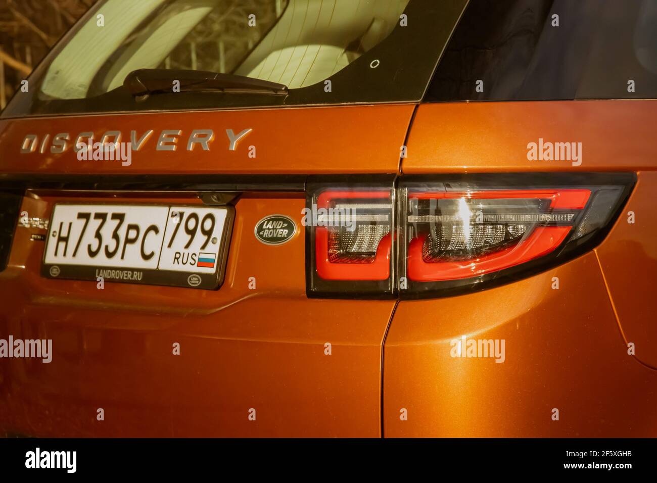 Moskau, Russland - 20. Dezember 2019: Der orange gefärbte Land Rover Discovery Sport 2020 ist direkt am Wasser geparkt. Außenansicht eines englischen Premium-SUV. Dreiviertel-Rückansicht. .. Stockfoto
