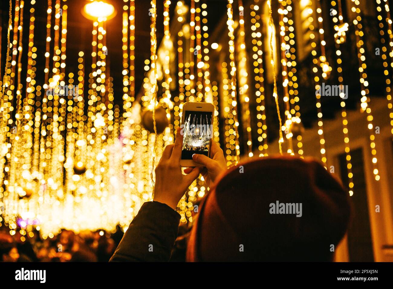 Das Mädchen macht Fotos von Weihnachten oder Silvester Lichter auf dem Telefon. Stockfoto