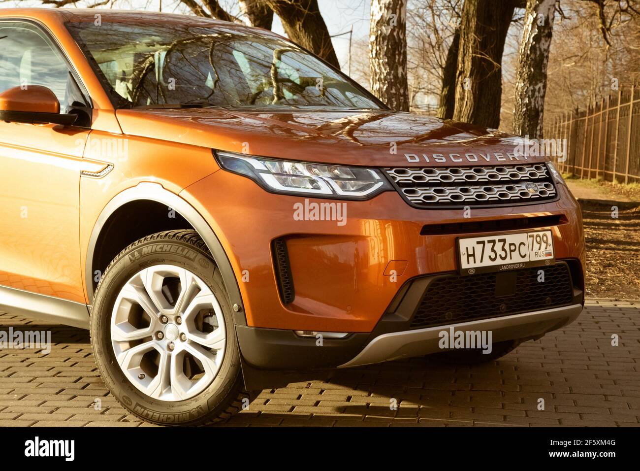 Moskau, Russland - 20. Dezember 2019: Der neue Land Rover Discovery Sport 2019 steht auf dem Park. Nahaufnahme der Vorderansicht der Seite. Scheinwerfer, Stoßfänger und Haube von orange suv, silberne Räder, .. Stockfoto
