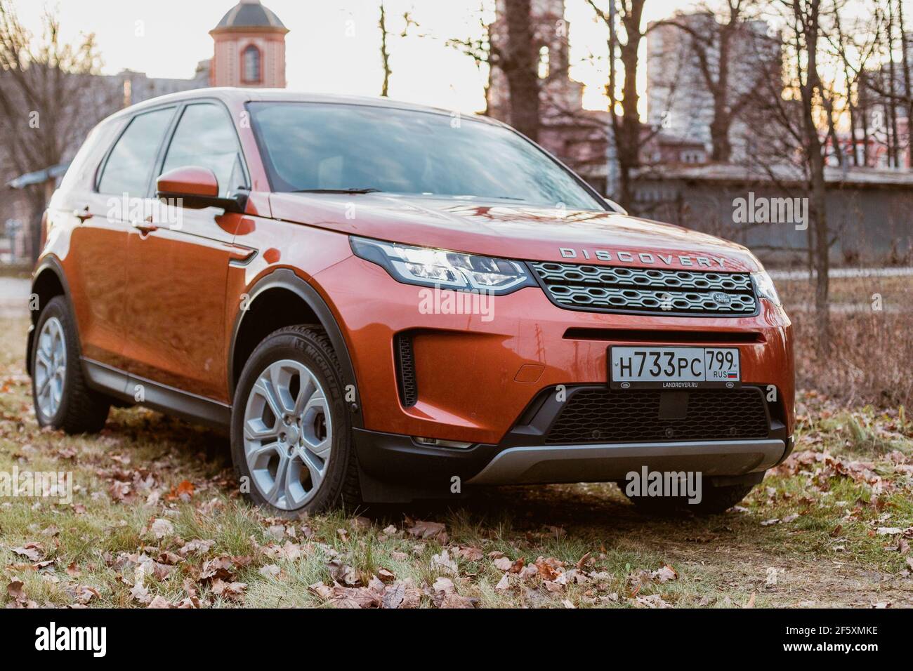 Moskau, Russland - 20. Dezember 2019: Vorderansicht des neuen Premium england suv. Land Rover Discovery Sport im grauen Wald geparkt. Orange Allradantrieb Auto steht auf dem Boden. Stockfoto