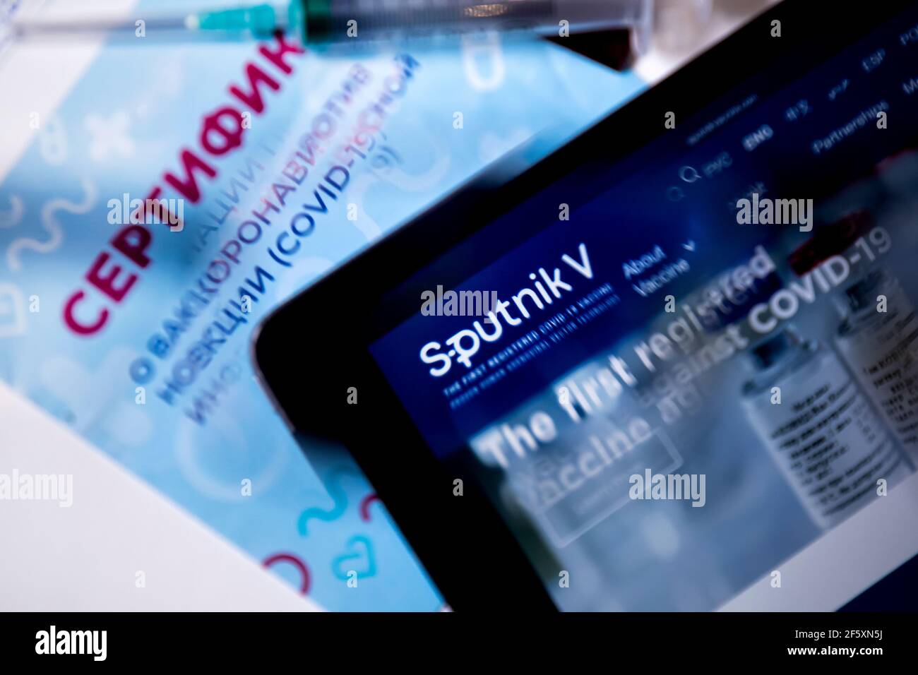 Blick auf die russische Impfbescheinigung gegen das neue Coronavirus Infektion COVID-19 und die Website des russischen Impfstoffs Sputnik V auf dem Tablet Stockfoto