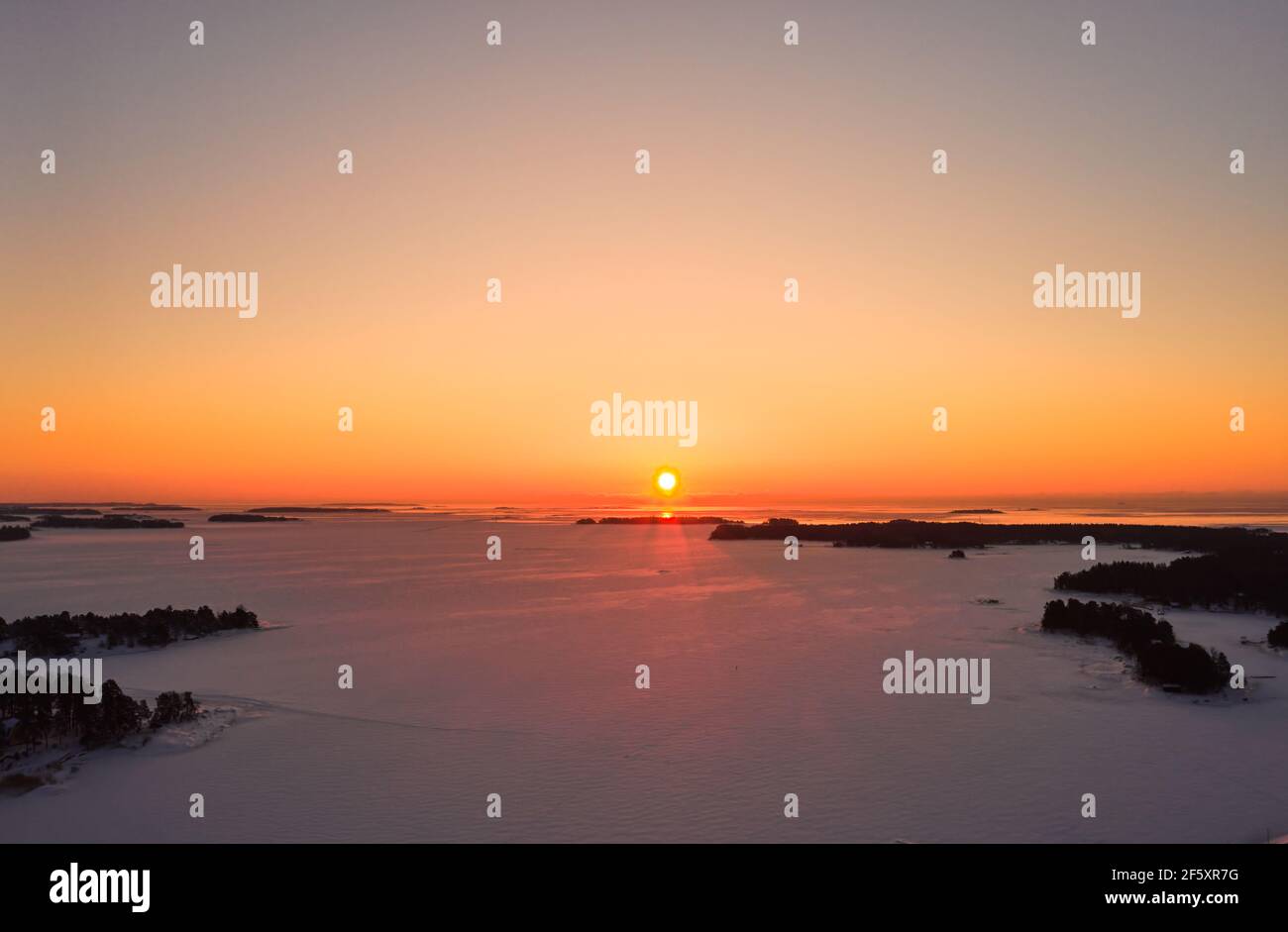 Luftaufnahme des Sonnenaufgangs über der eisbedeckten Ostsee im Winter. Stockfoto