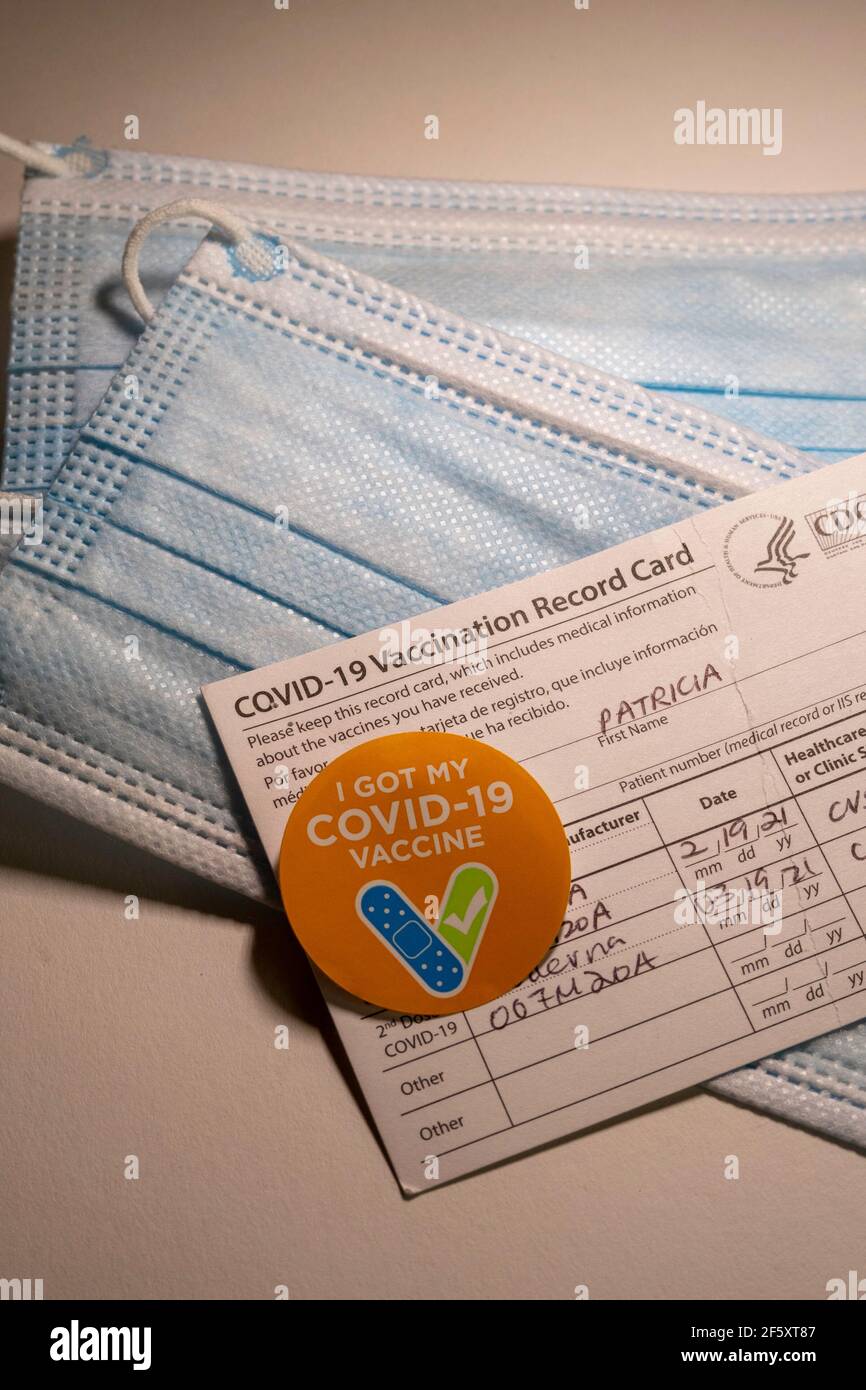 Aufkleber „I got my COVID-19 Vaccine“ mit Record Card und schützenden Gesichtsmasken, USA Stockfoto