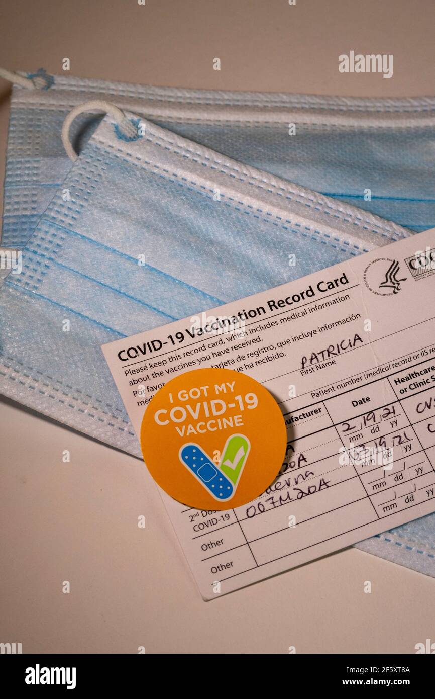Aufkleber „I got my COVID-19 Vaccine“ mit Record Card und schützenden Gesichtsmasken, USA Stockfoto