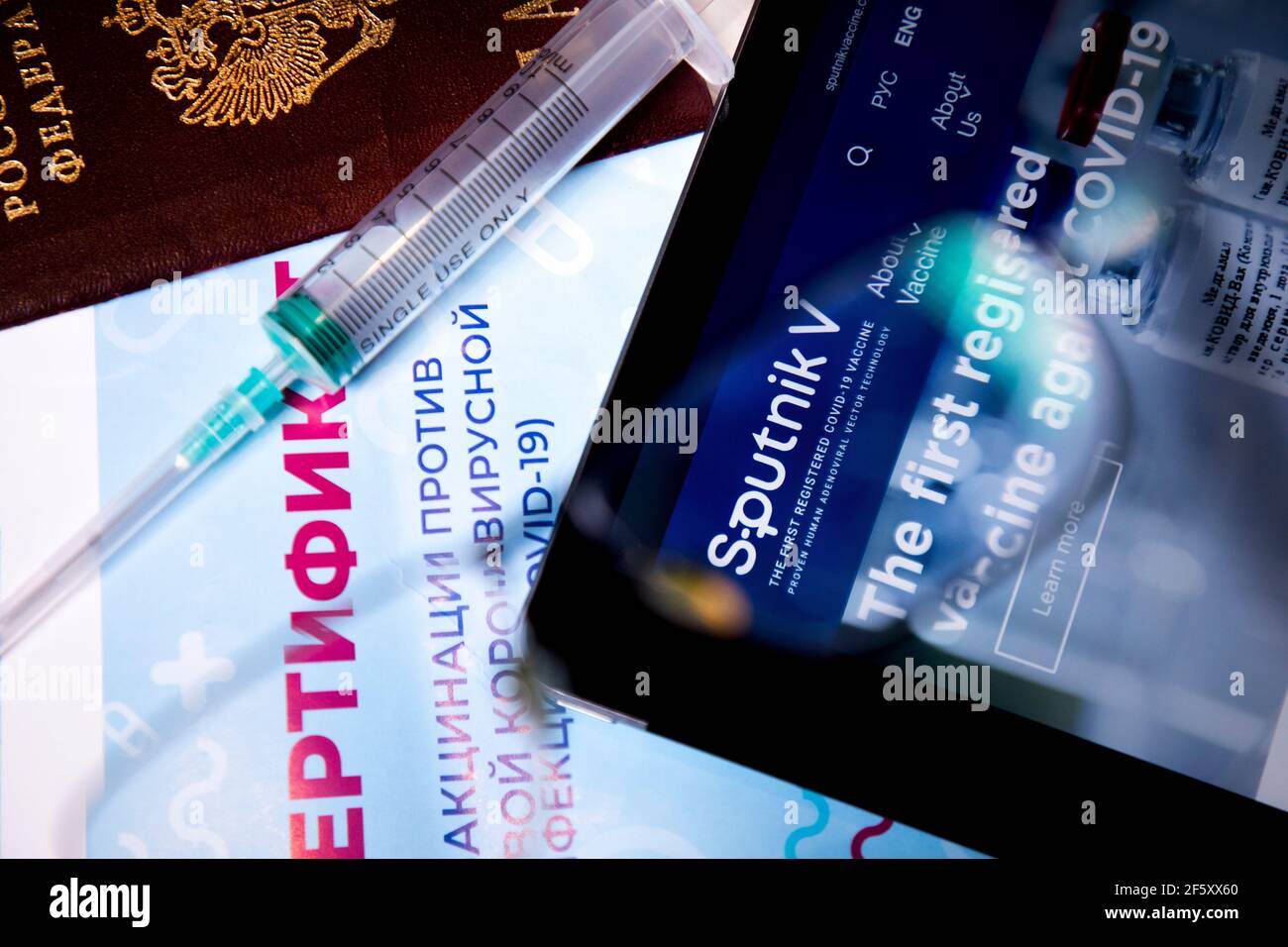 Blick auf die russische Impfbescheinigung gegen das neue Coronavirus Infektion COVID-19 und die Website des russischen Impfstoffs Sputnik V auf dem Tablet Stockfoto