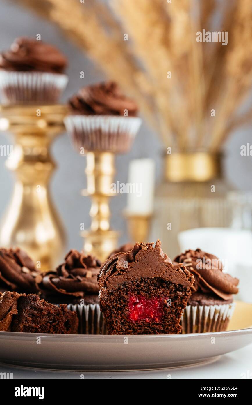 Schokoladen-Cupcakes mit Beerenfüllung und Schokoladencreme Stockfoto