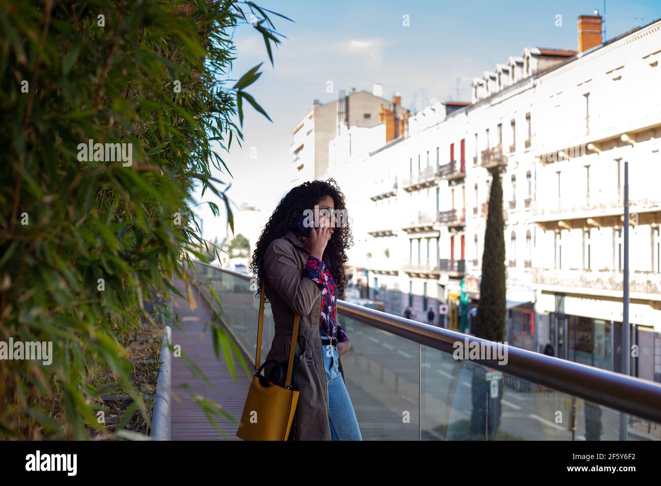 Glückliche afroamerikanische junge Frau im Gespräch mit Handy in der Stadt Stockfoto