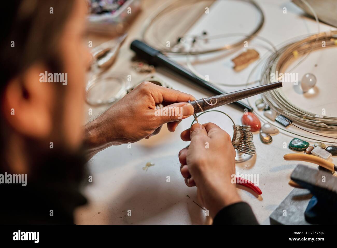 Nahaufnahme der Hände des Kunsthandwerkers Juwelier arbeiten an der Arbeitstisch in der Werkstatt Stockfoto