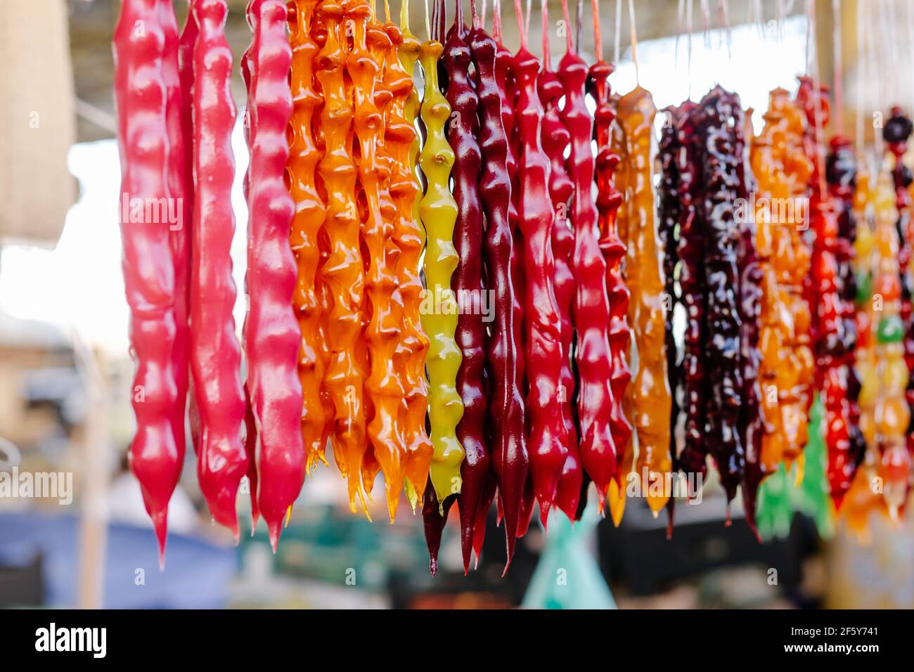 Bunte hausgemachte Süßigkeiten Churchkhela mit Haselnüssen, Walnüssen, Traubensaft, Honig oder Zucker, Weizen oder Maismehl. Dessert in lokalen Lebensmittelmarkt verkauft. Stockfoto Bunte hausgemachte Süßigkeiten Churchkhela mit Haselnüssen, Walnüssen, Traubensaft, Honig oder Zucker, Weizen oder Maismehl. Dessert in lokalen Lebensmittelmarkt verkauft. Stockfoto