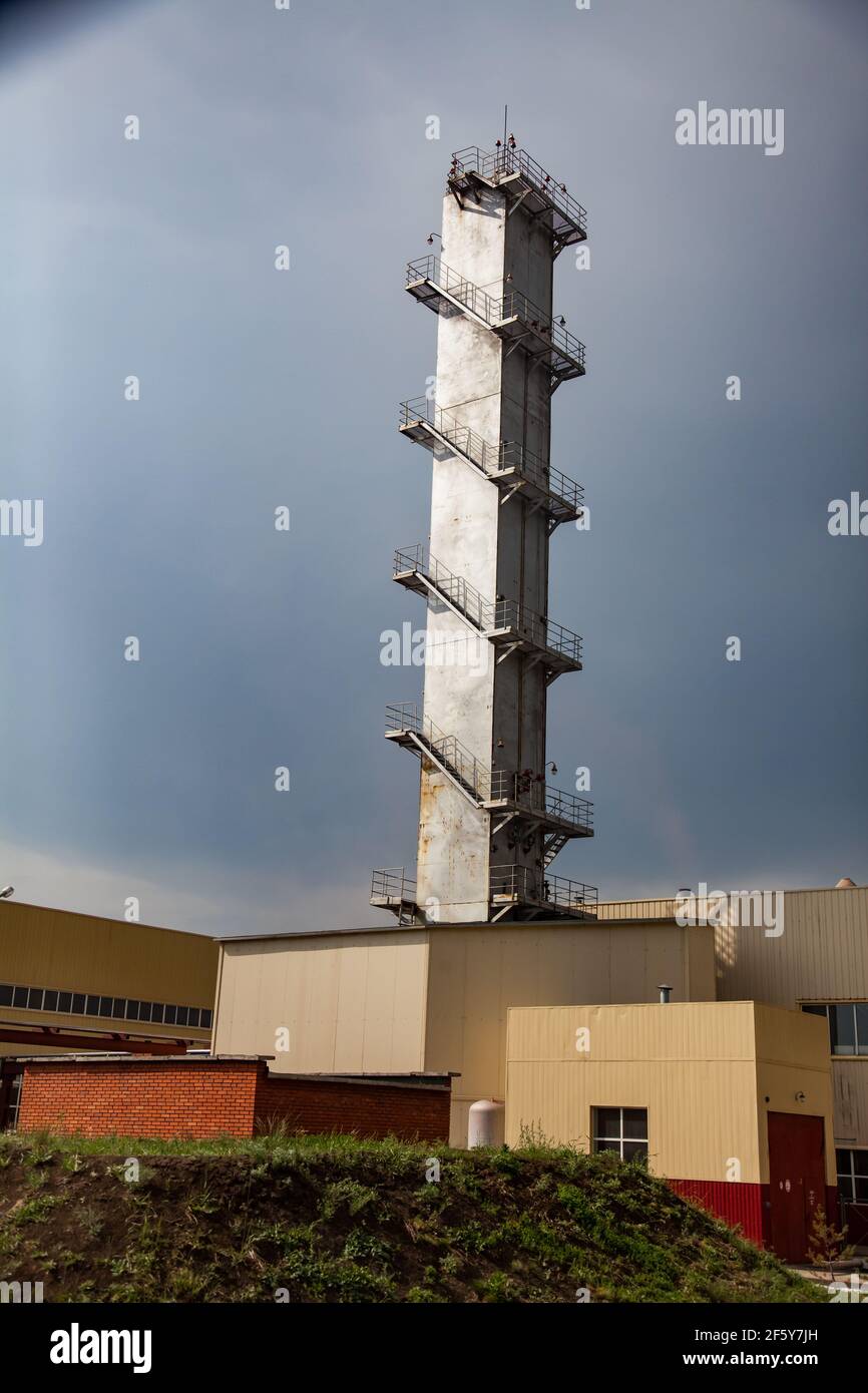 Sokolovo-Sarbay Bergbau-und Verarbeitungsanlage. Grauer Betonturm mit Treppe am grauen Himmel. Abstrakte industrielle Sicht. Stockfoto