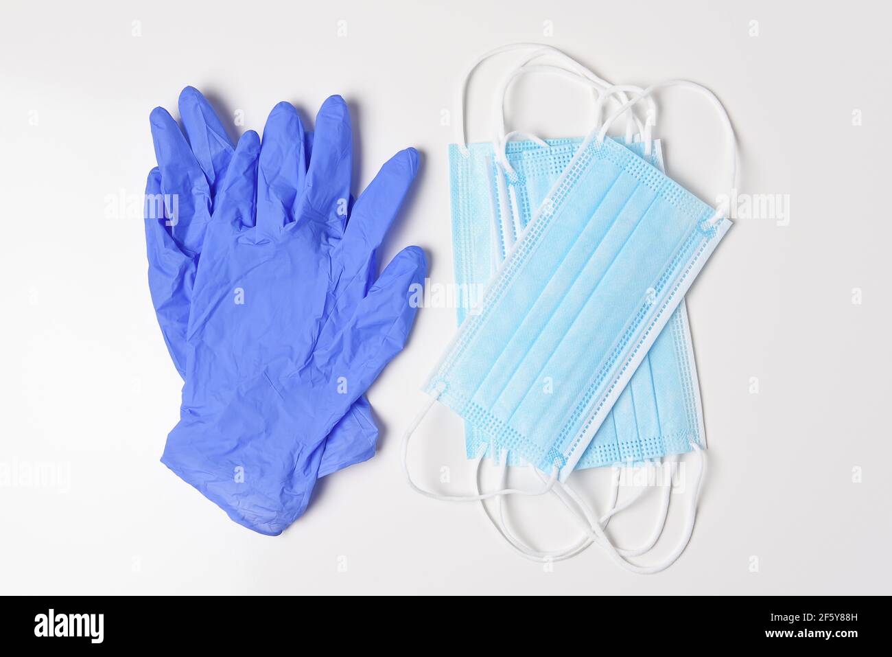 Eine Gruppe von medizinischen Masken und lates Handschuhe auf weiß, High-Angle-Schuss. Stockfoto