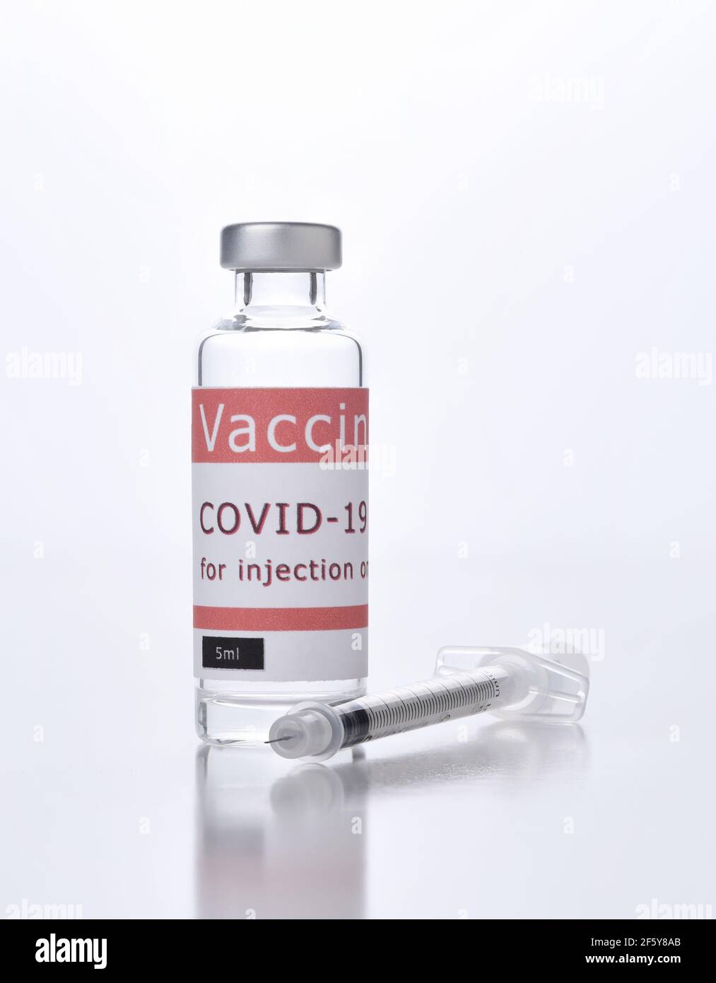 Nahaufnahme eines Covid-19-Impfstofffläschchens und einer Spritze auf Weiß. Stockfoto