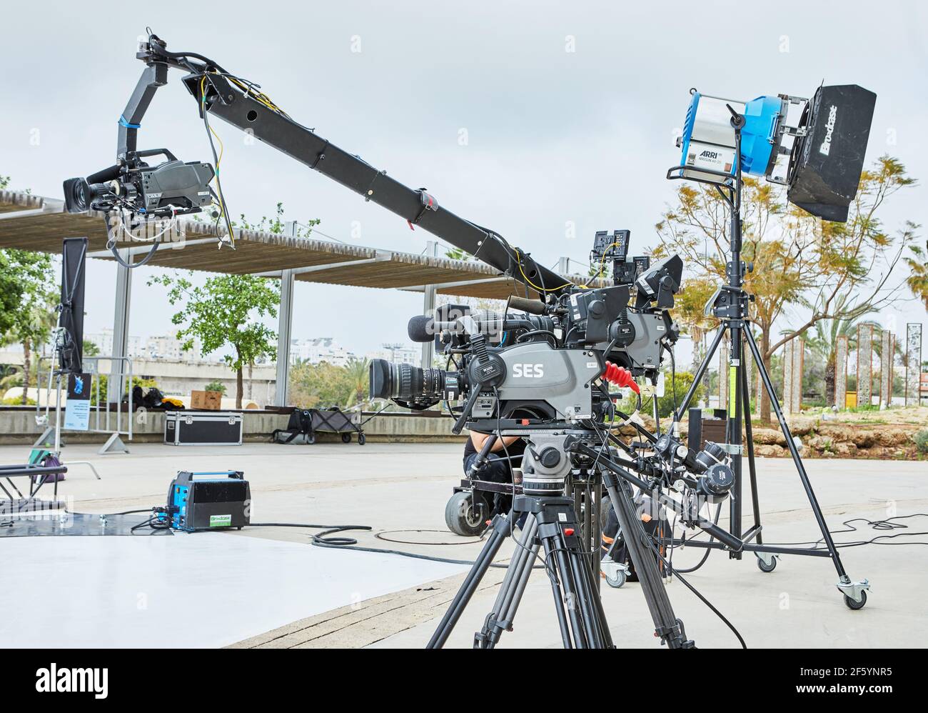 Professionelle Ausrüstung zum Filmen von Fernsehsendungen und Filmen. Eine Videokamera auf Stativ und Beleuchtungsgerät. Stockfoto