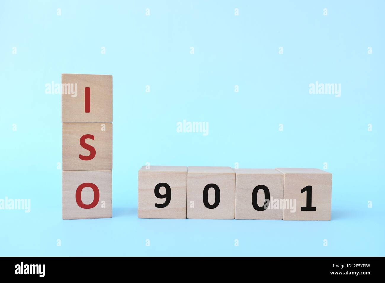 ISO 9001 oder Quality Management Systems Konzept auf Holzblöcken auf blauem Hintergrund. Stockfoto