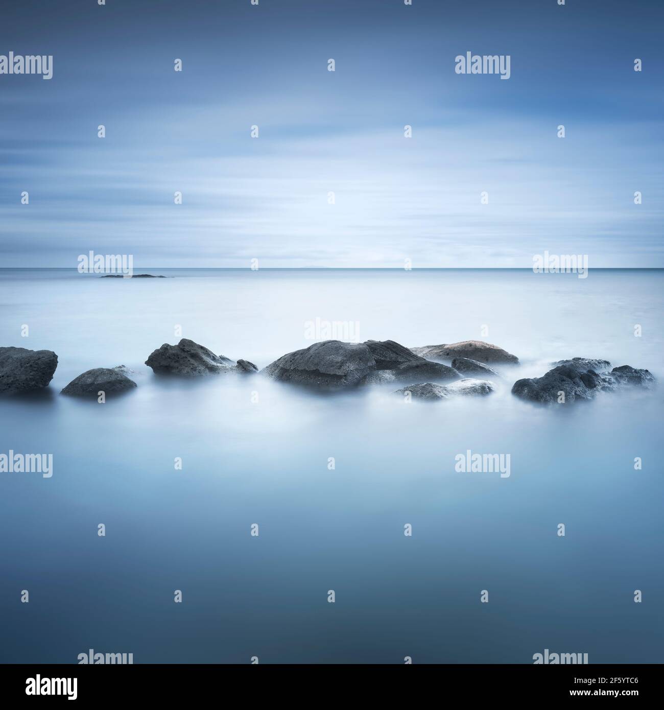 Felsen, weiches Meer und Wolken am Himmel, schöne Landschaft in Langzeitbelichtung Fotografie. Castiglioncello, Toskana, Italien. Stockfoto