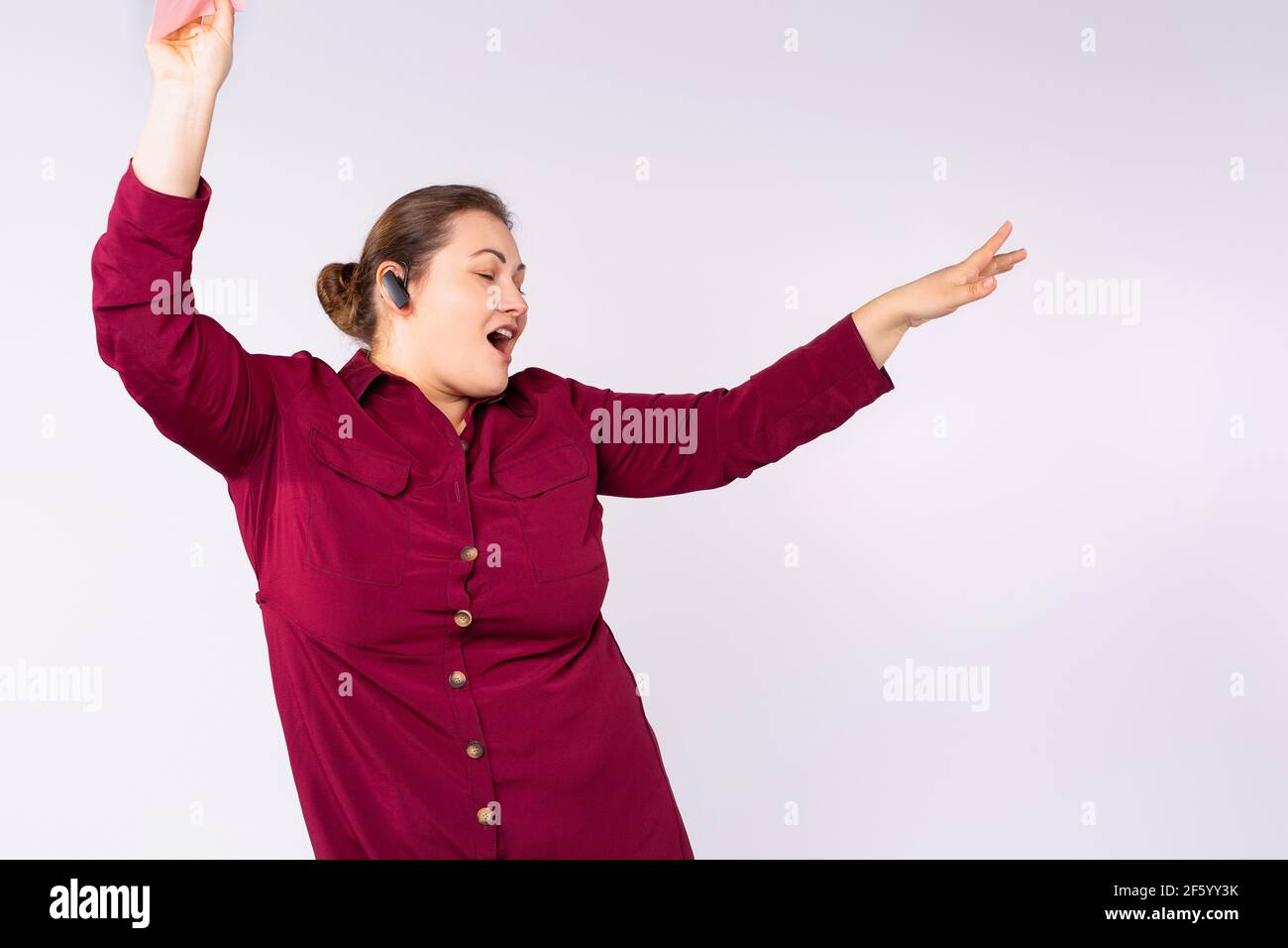 Kopfhörer Musikkonzept, große Frau tanzt auf der Straße, kabelloses Melodiesymbol. Plump Frau hört Musik, Stadt Multimedia. Streaming Stockfoto