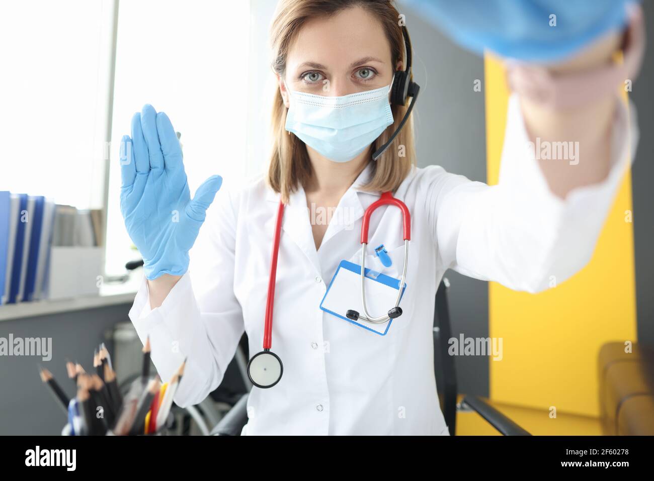 Arzt in Schutzmaske öffnen Deckel des Laptops und winken Seine Hand Stockfoto