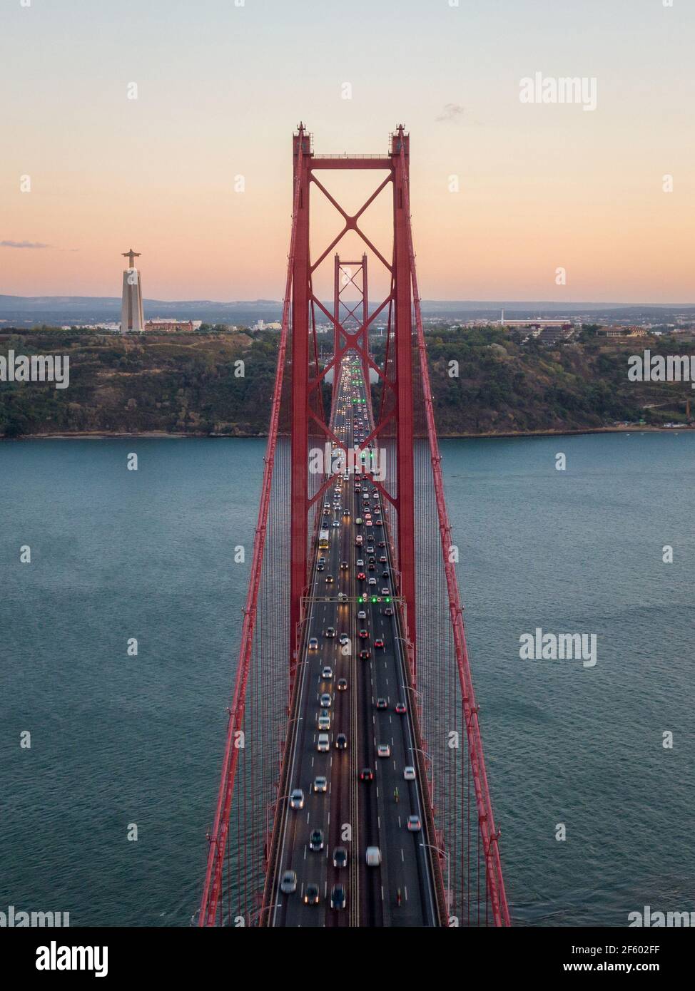 Luftaufnahme des Verkehrs auf der Brücke vom 25. April (Portugiesisch: Ponte 25 de Abril) über den Tejo bei Sonnenuntergang in Lissabon, Portugal. Stockfoto