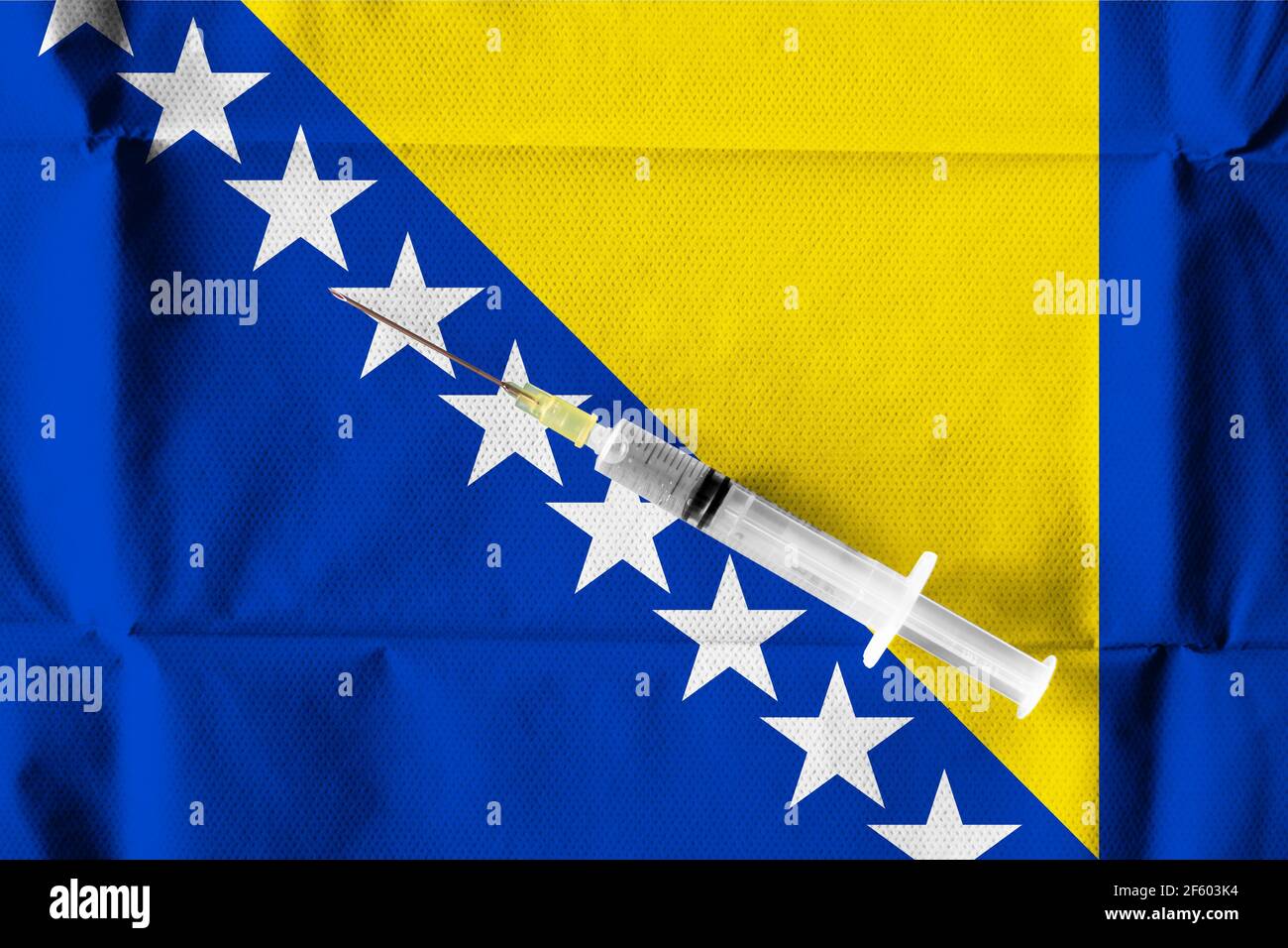 Konzept der laufenden Bemühungen von Bosnien und Herzegowina, COVID-19-Impfstoff mit einer gebrauchsfertigen Spritze unter bosnischer Flagge zu liefern und zu verteilen. Stockfoto