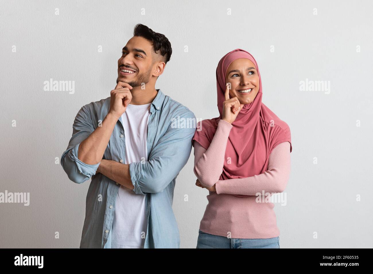 Nachdenkliches junges muslimisches Paar, das über etwas nachdenkt und wegschaut Stockfoto