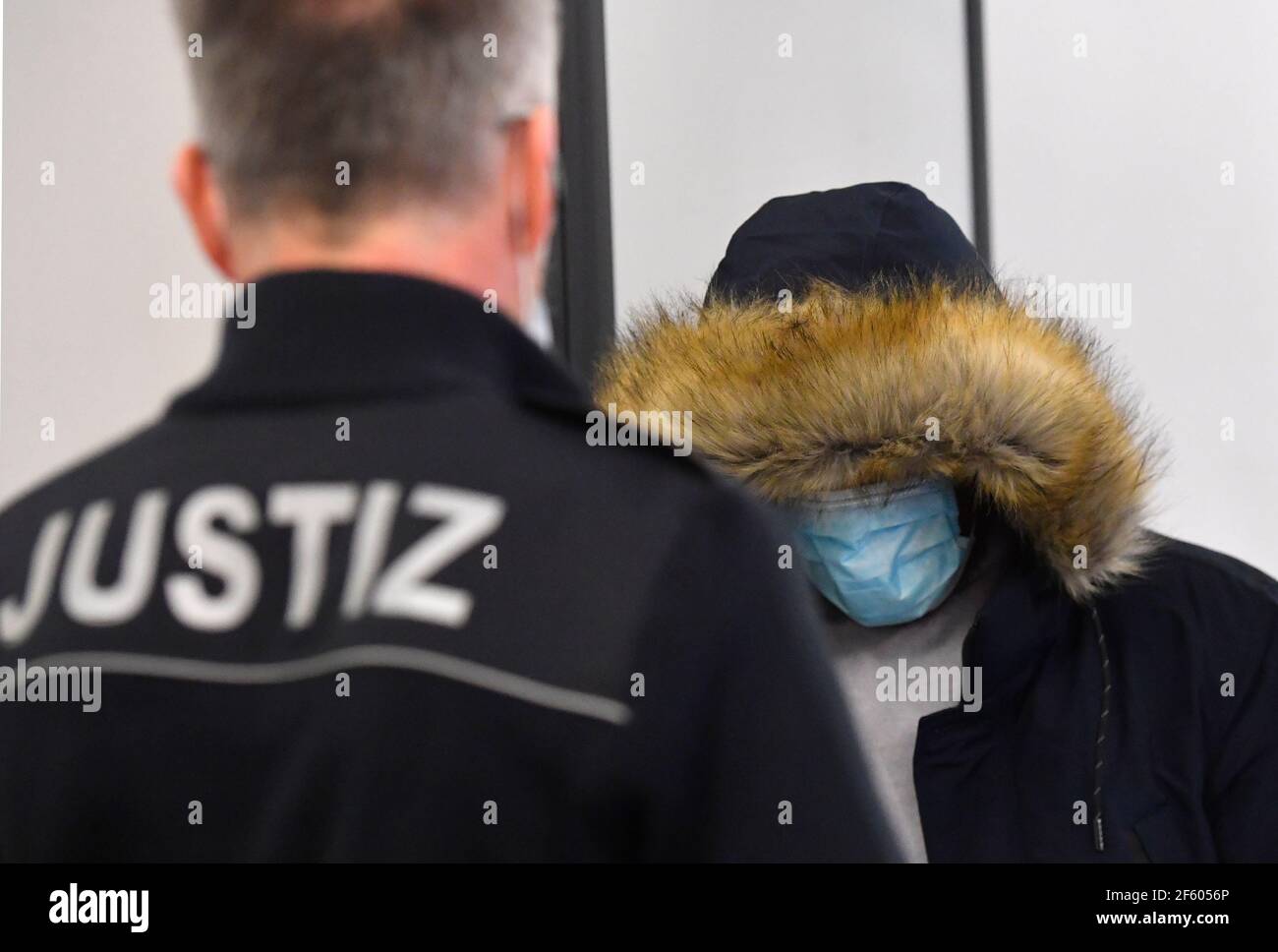 Dresden, Deutschland. März 2021, 29th. Einer von insgesamt drei Angeklagten kommt zum Beginn des Prozesses gegen Mitglieder der Gruppe "Faust des Ostens" vor das Landgericht Dresden. Die Männer werden der Mitgliedschaft in einer kriminellen Organisation, Diebstahl und Angriff beschuldigt. Sie werden für "gewalttätige Angriffe auf Mitglieder anderer Fußballmannschaften, Polizisten und Personen mit fremdem Aussehen" in der Nähe von Fußballspielen des damaligen Zweitligisten Dynamo Dresden verantwortlich gemacht. Quelle: Matthias Rietschel/dpa-Zentralbild/dpa/Alamy Live News Stockfoto