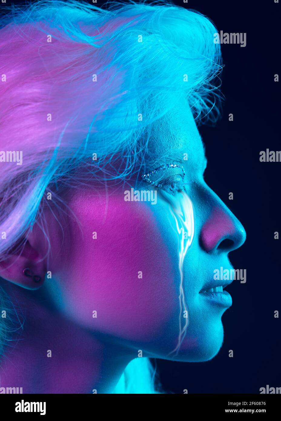 Porträt einer jungen schönen Frau mit Neon, fließende Tränen aus den Augen. Konzept von Mode und Schönheit, Emotionen und Gefühle, modernes Design Stockfoto