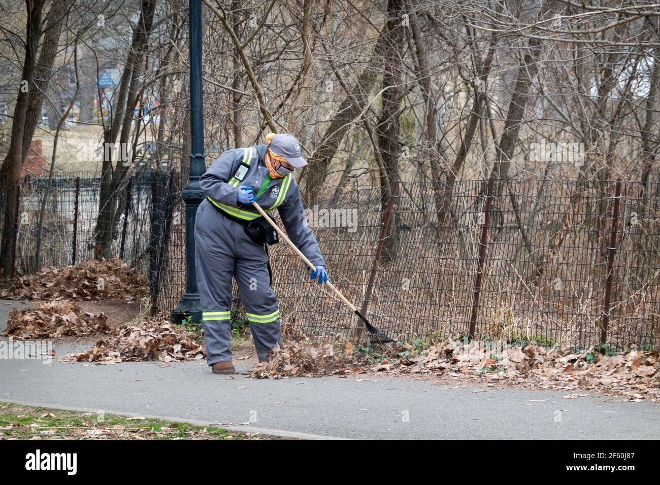 Im späten Winter rechen Mitarbeiter der Abteilung des NYC Parks Blätter in einem Park in Queens, New York City. Stockfoto