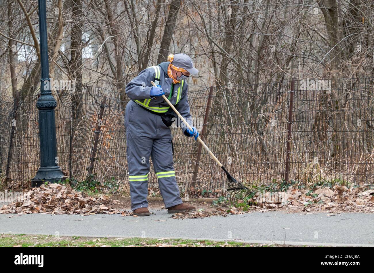 Im späten Winter rechen Mitarbeiter der Abteilung des NYC Parks Blätter in einem Park in Queens, New York City. Stockfoto