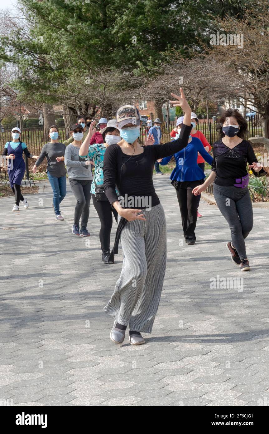 Ein schlanker anmutiger chinesisch-amerikanischer Lehrer unterrichtet in einem Park in Queens, New York City, eine Tanzübung. Stockfoto