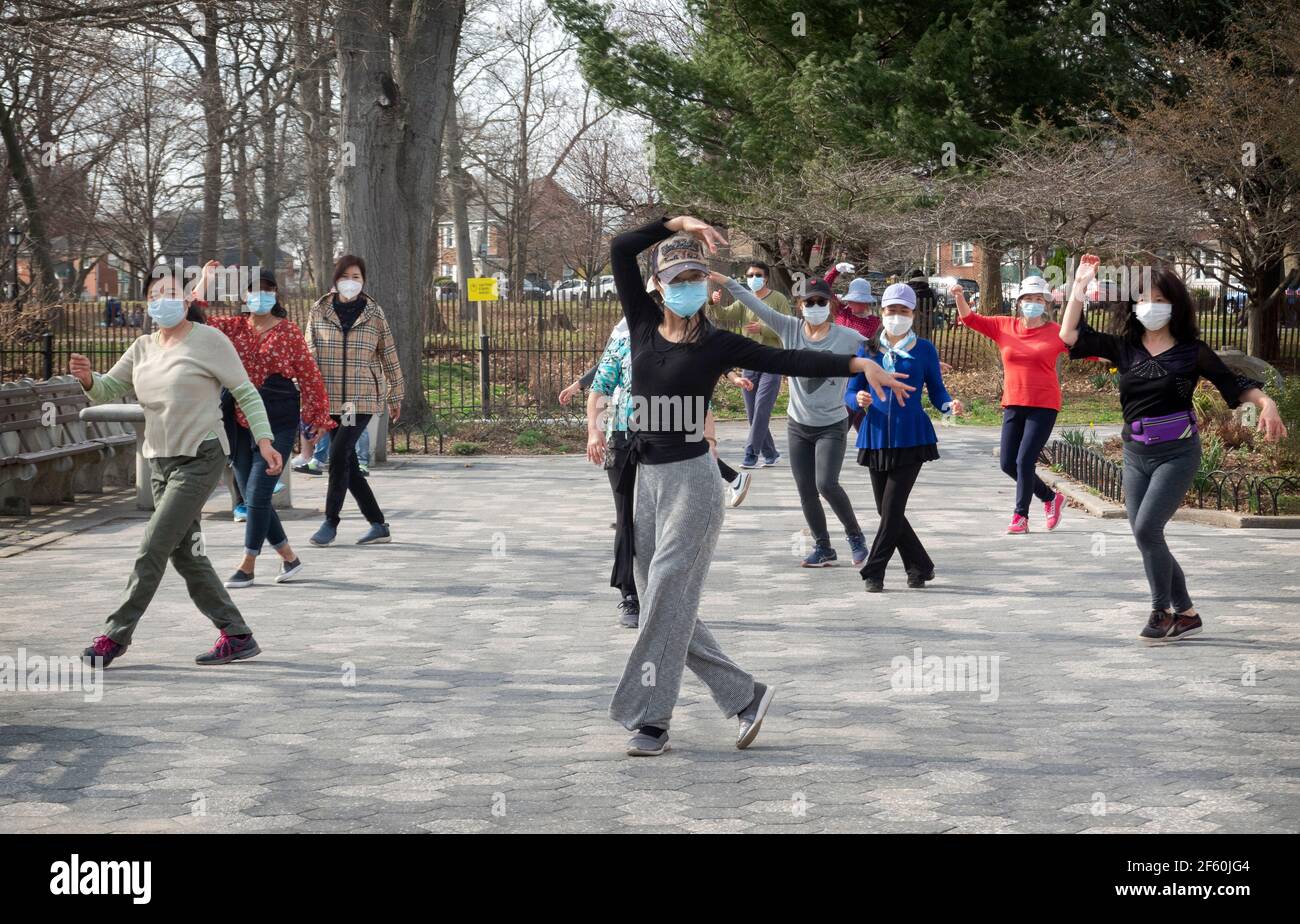 Ein schlanker anmutiger chinesisch-amerikanischer Lehrer unterrichtet in einem Park in Queens, New York City, eine Tanzübung. Stockfoto
