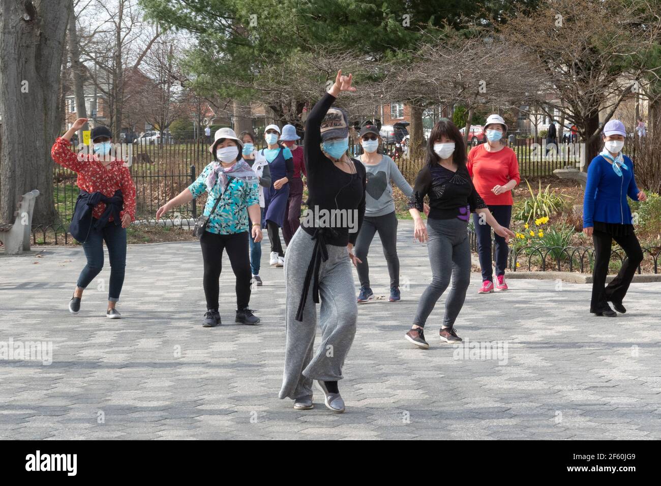 Ein schlanker anmutiger chinesisch-amerikanischer Lehrer unterrichtet in einem Park in Queens, New York City, eine Tanzübung. Stockfoto
