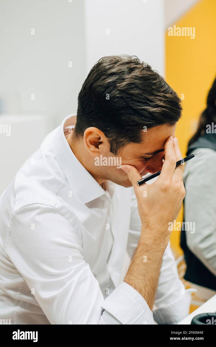 Besorgter Geschäftsmann, der im Büro arbeitet Stockfoto