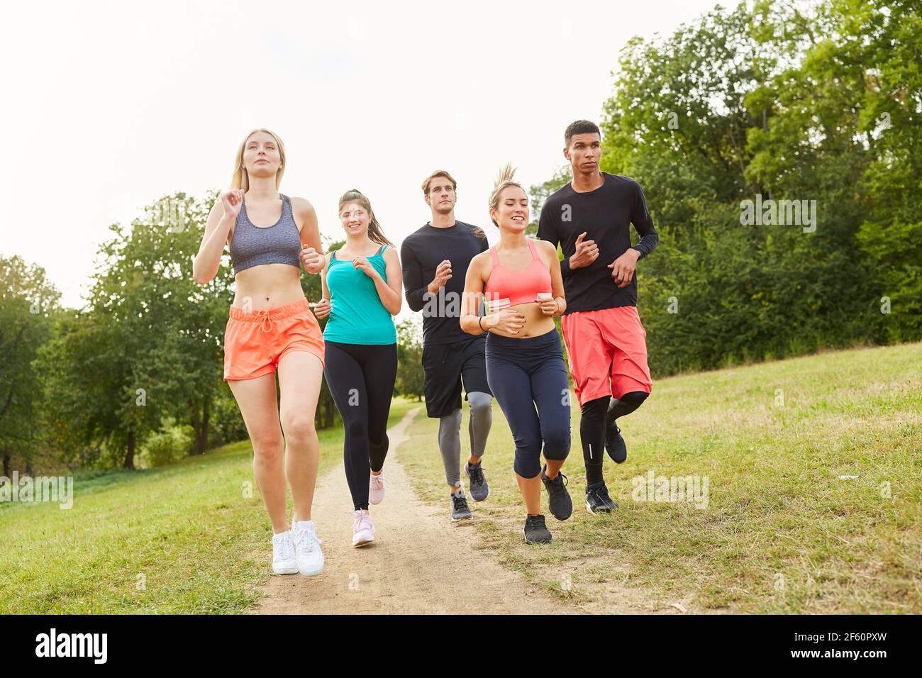 Gruppe von jungen Menschen joggen im Park im Sommer Für Ausdauer und Fitness Stockfoto