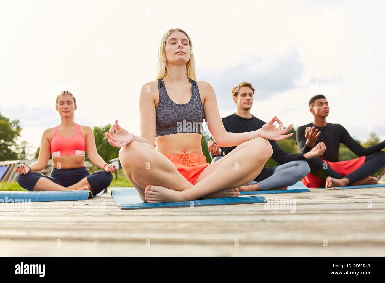Gruppe von jungen Menschen genießen eine Zen-Meditation in einem Yoga-Workshop in der Natur Stockfoto