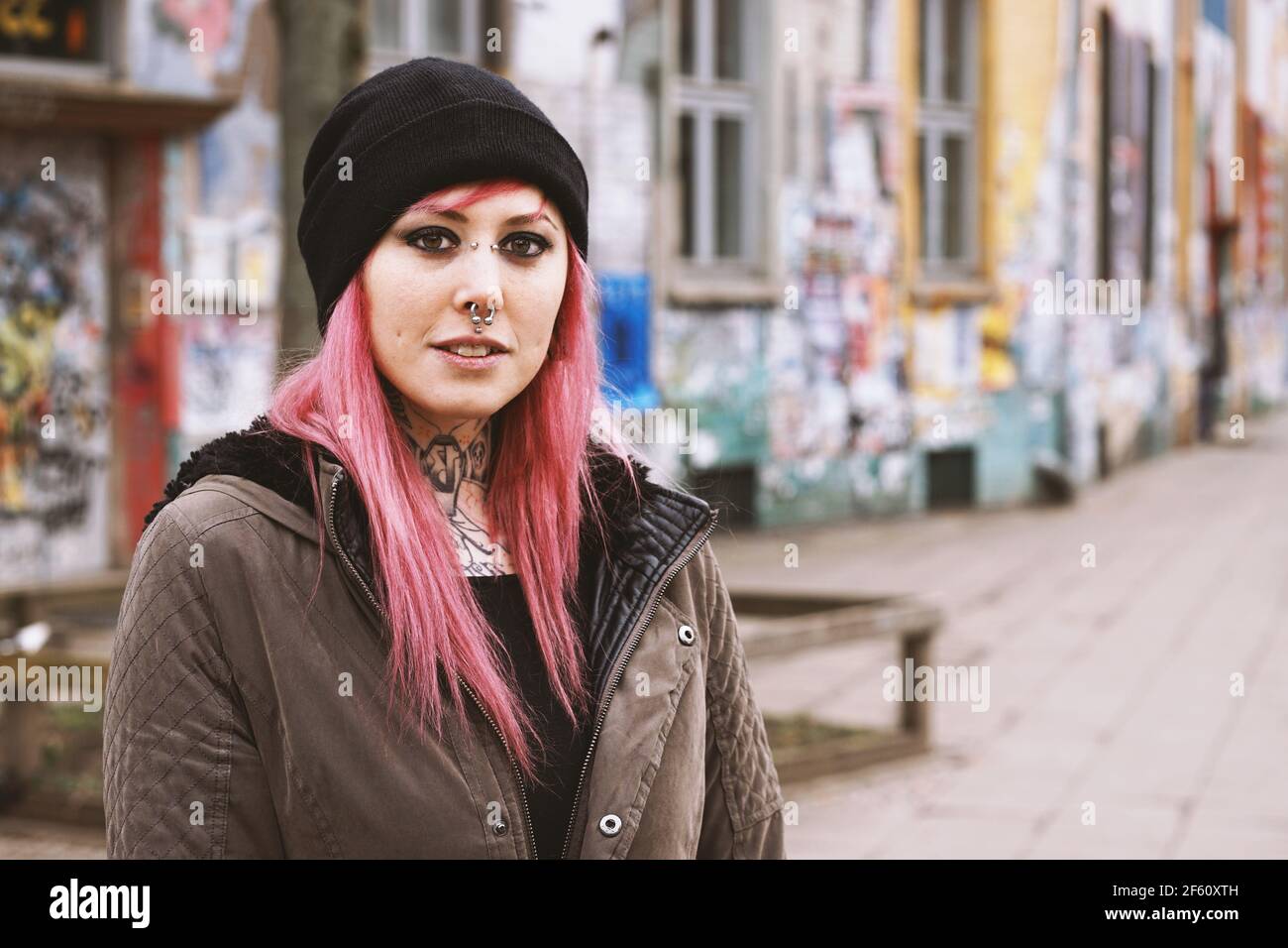 Vor heruntergekommenen Graffiti eine junge Frau durchbohrt und eingeschlagen Überdachte Häuser Stockfoto