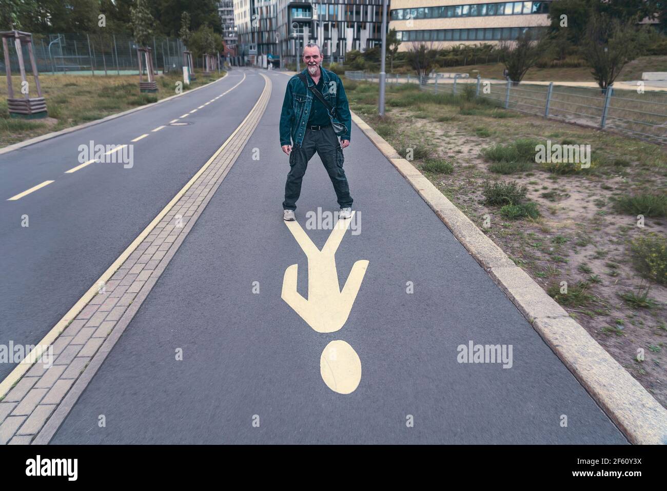 Lachend steht der ältere Mann auf einem Fußgängerschild Stockfoto