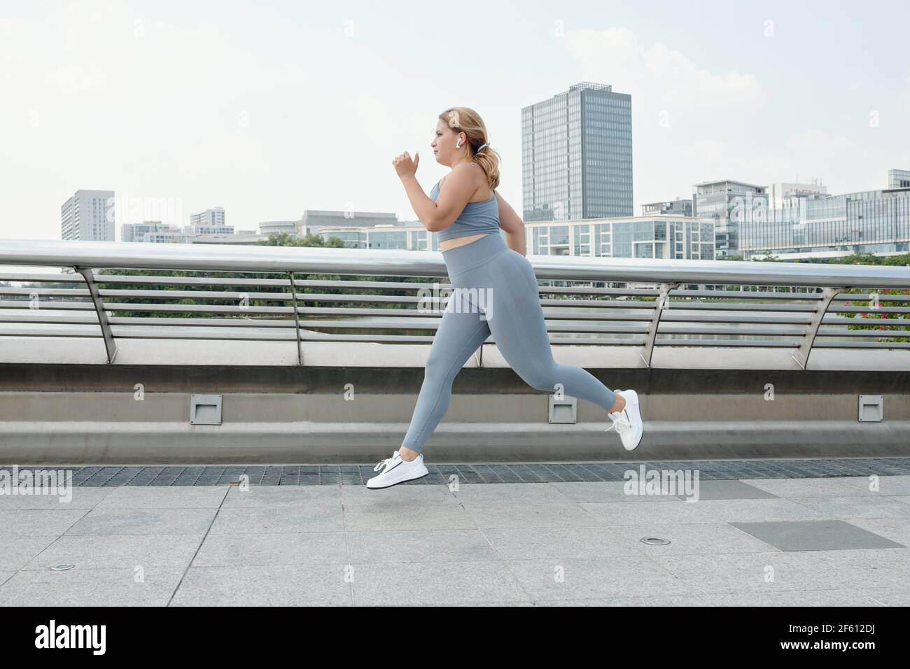 Fit plus size junge Frau Musik beim Laufen hören Outdoor und Training für Marathon Stockfoto