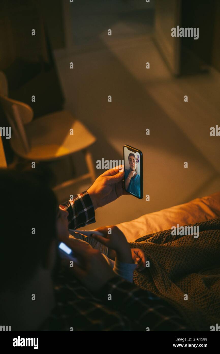 High-Angle-Ansicht von kranken Mann Online-Beratung durch Video Telefonieren Sie zu Hause auf dem Smartphone Stockfoto