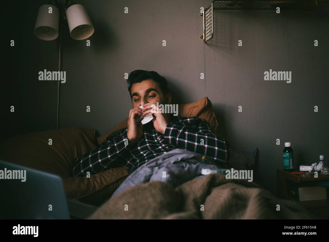 Mann bläst Nase, während Online-Beratung zu Hause Stockfoto