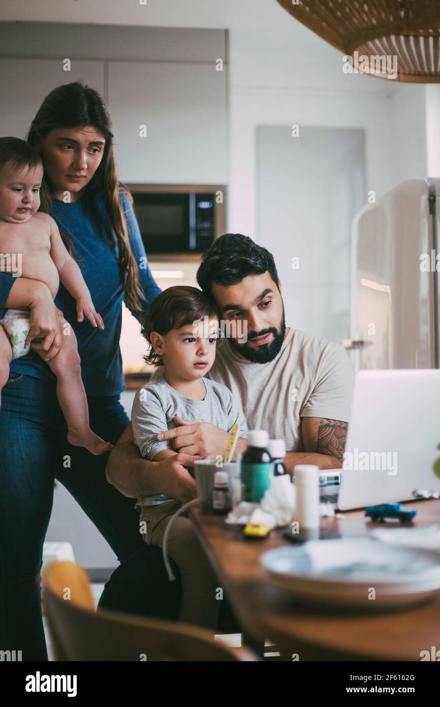 Familienberatung online über Videoanruf über Laptop in der Küche Während des Covid-19 Stockfoto